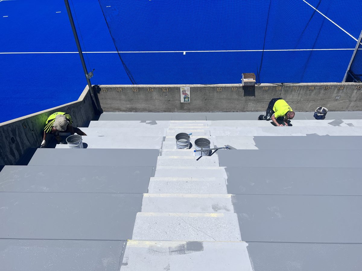 PWSS team applying waterproof membrane to stadium grandstand seating area